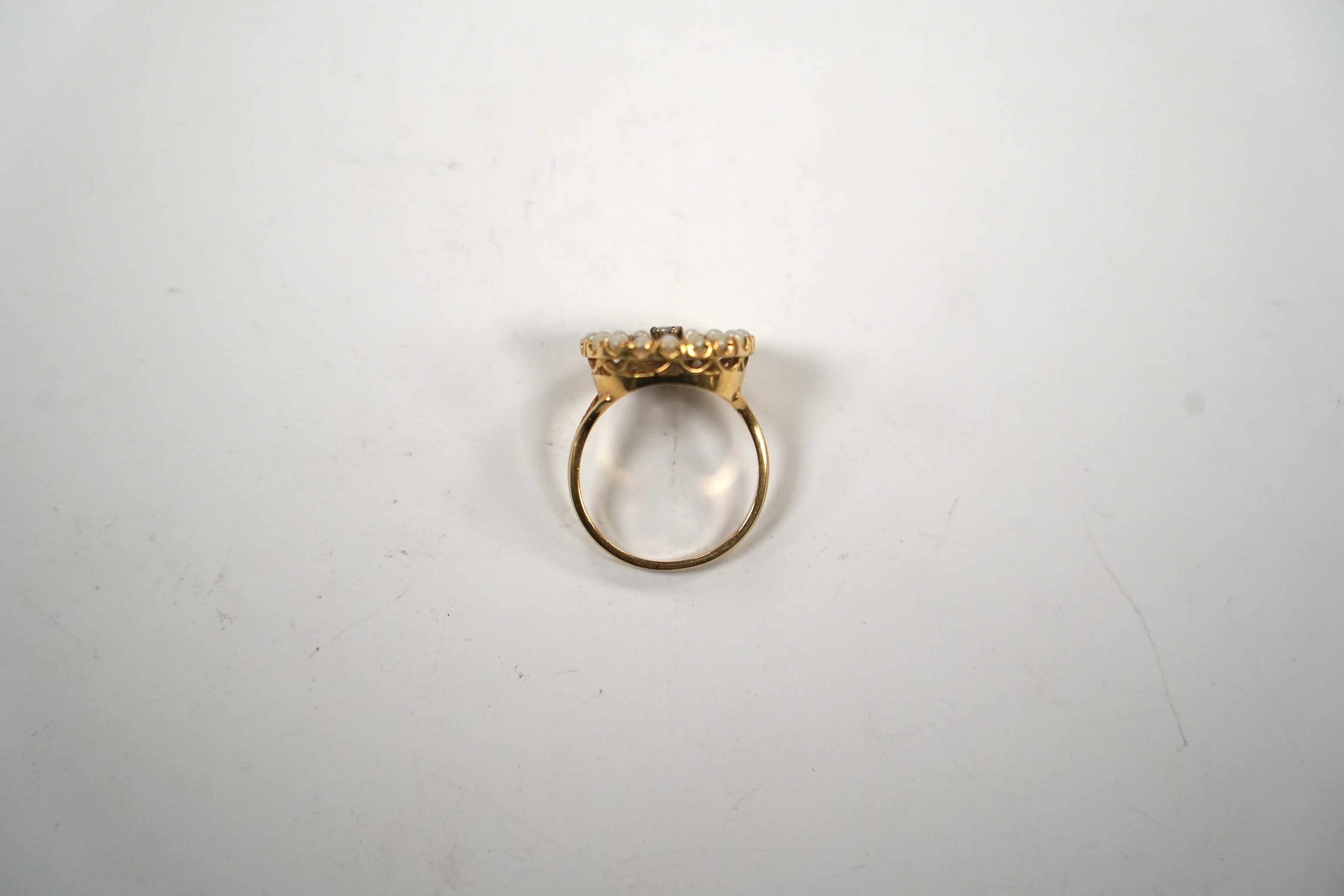 A pierced 14k yellow metal, seed pearl and diamond cluster set circular ring, size P/Q, gross weight 5.2 grams.